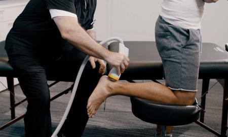 shockwave therapy being applied to a patient's ankle'